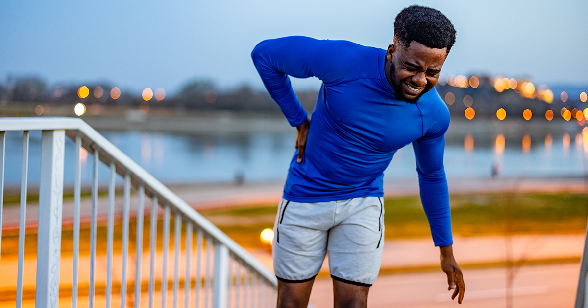 Athlete rubbing his back.